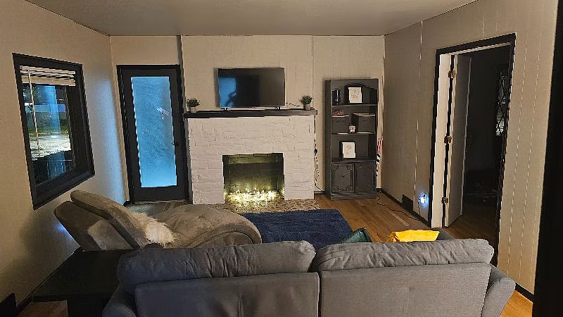 Living room with fireplace, sectional sofa and wall-mounted TV